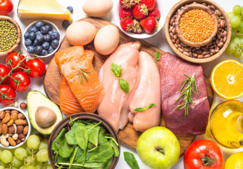 Balanced diet food background. Healthy nutrition. Ketogenic low carbs diet. Meat, fish, nuts, vegetables, oil, beans, lentils fruits and berries on white background. Top view